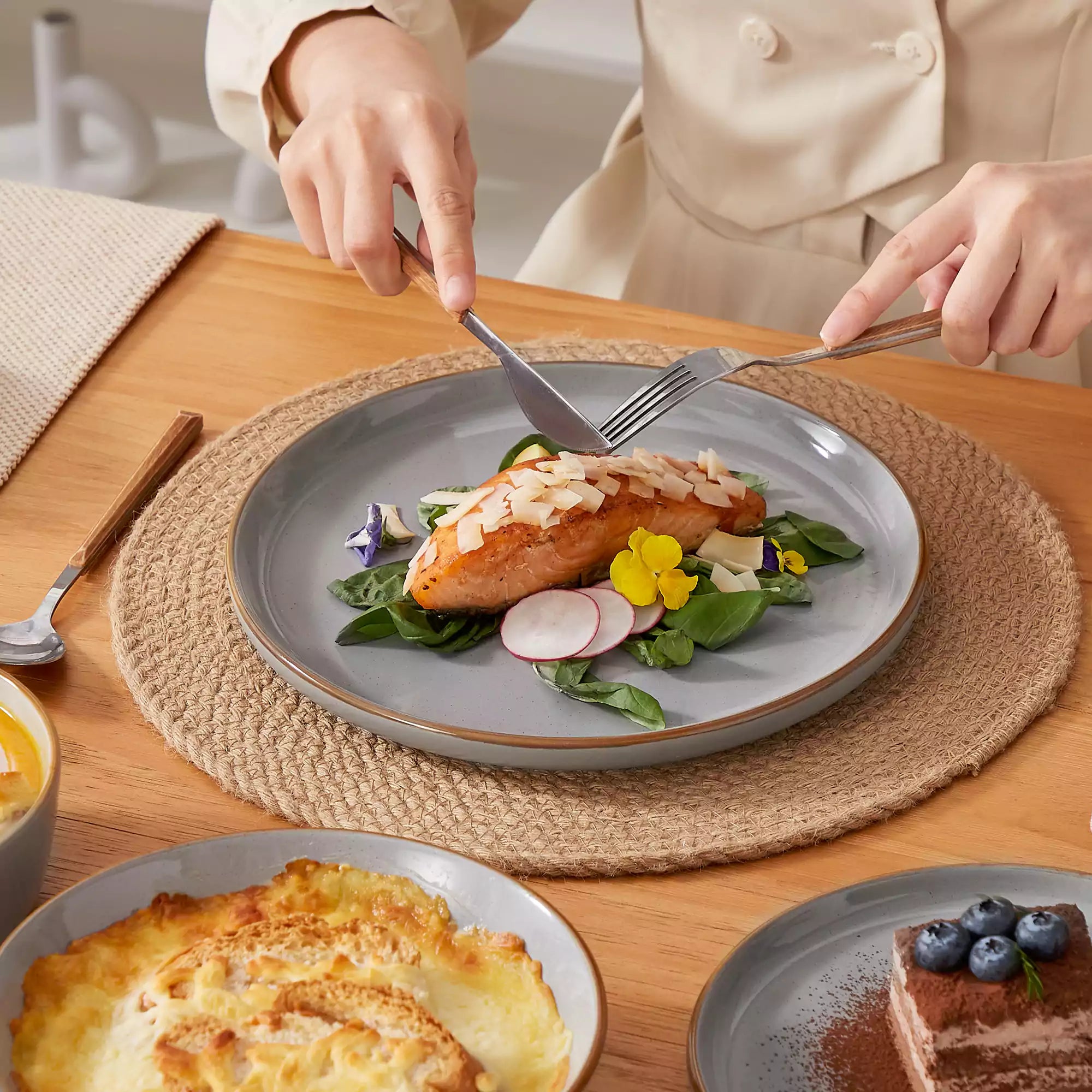 Rustic grey speckled stoneware dinnerware set with lipped-edge plates and bowls arranged on a sunlit modern dining table-vancasso
