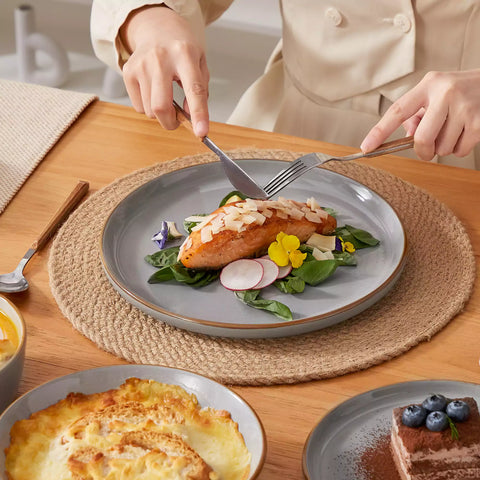 Rustic grey speckled stoneware dinnerware set with lipped-edge plates and bowls arranged on a sunlit modern dining table-vancasso