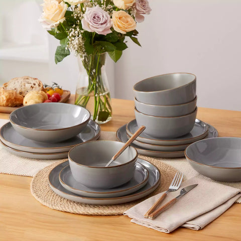 Rustic grey speckled stoneware dinnerware set with lipped-edge plates and bowls arranged on a sunlit modern dining table-vancasso