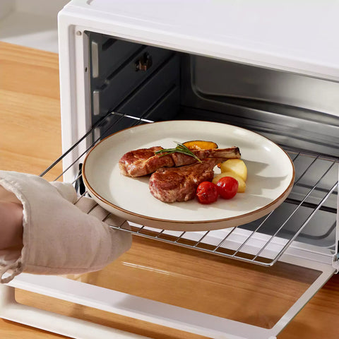 Assorted rustic stoneware dinnerware set with speckled - lipped-edge plates and bowls on a dining table with flowers and cutlery in a cozy modern kitchen-vancasso