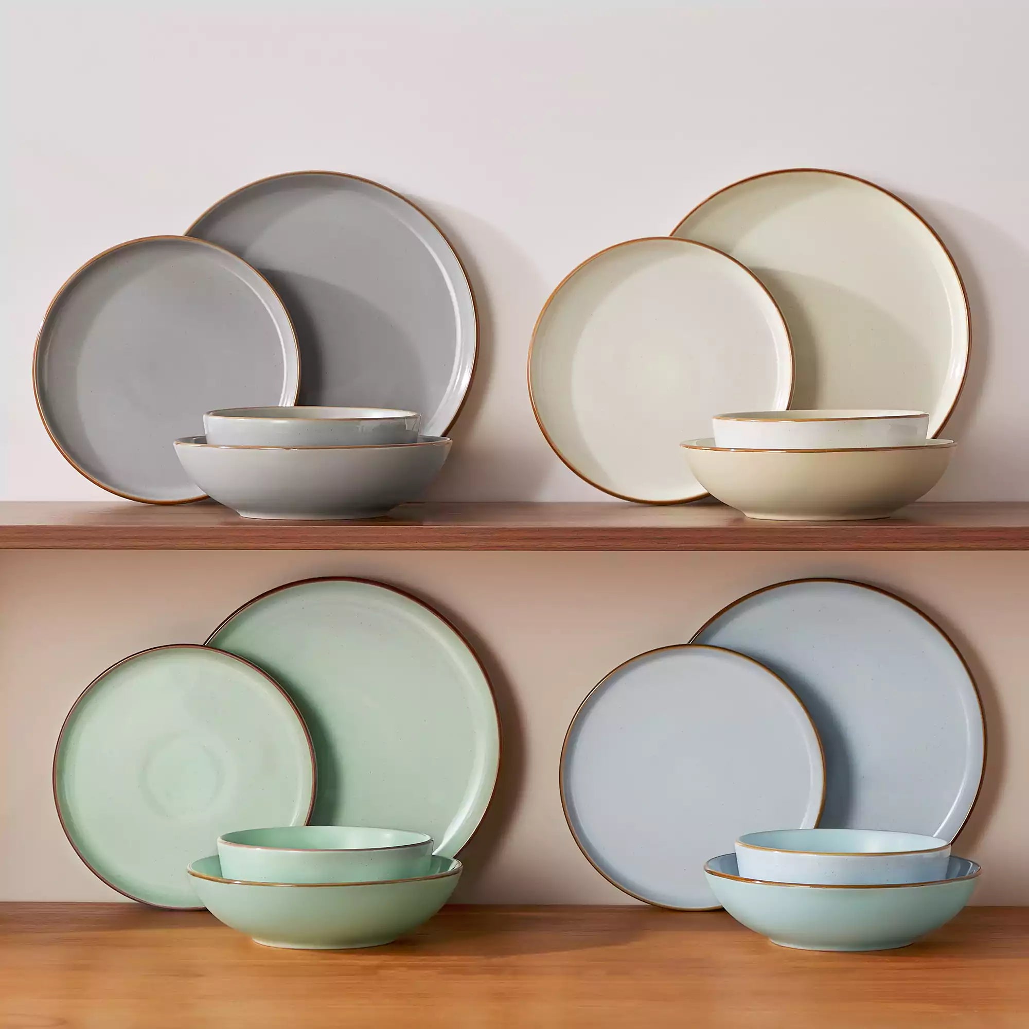 Rustic assorted speckled stoneware dinnerware set with lipped-edge plates and bowls arranged on a sunlit modern dining table-vancasso