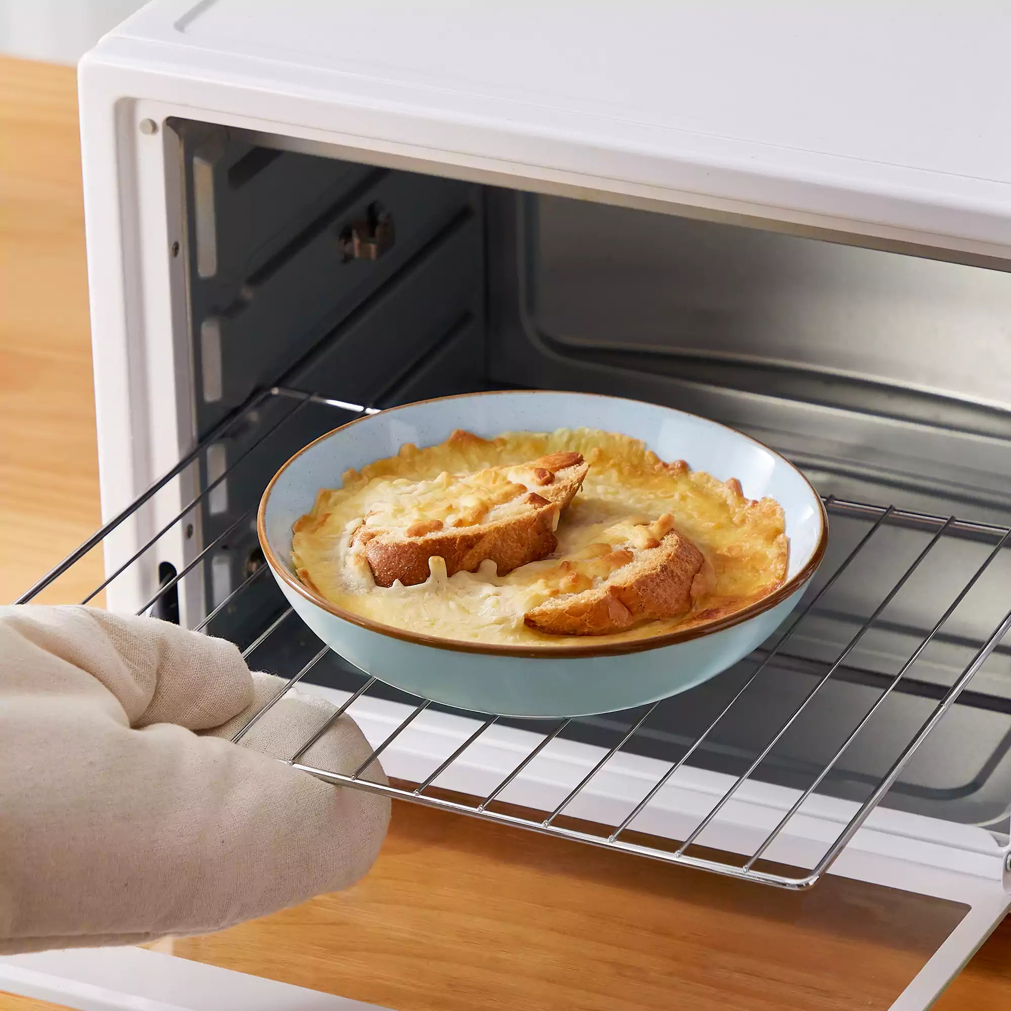 Rustic assorted speckled stoneware dinnerware set with lipped-edge plates and bowls arranged on a sunlit modern dining table-vancasso