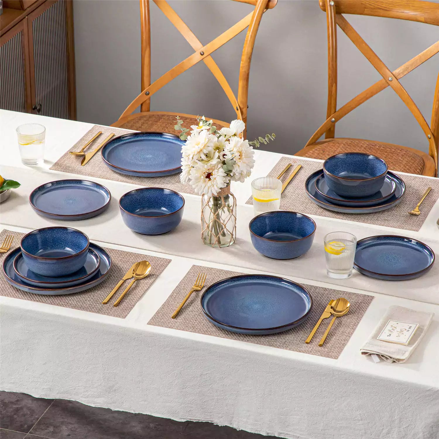 Sata blue stoneware 12 piece dinnerware set with dinner plates salad plates and cereal bowls styled with gold cutlery on textured surface farmhouse reactive glaze lipped edge service for 4