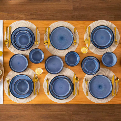 Sata blue stoneware 18 piece dinnerware set with dinner plates salad plates and cereal bowls styled on a wooden table with diverse meal setup farmhouse reactive glaze lipped edge service for 6