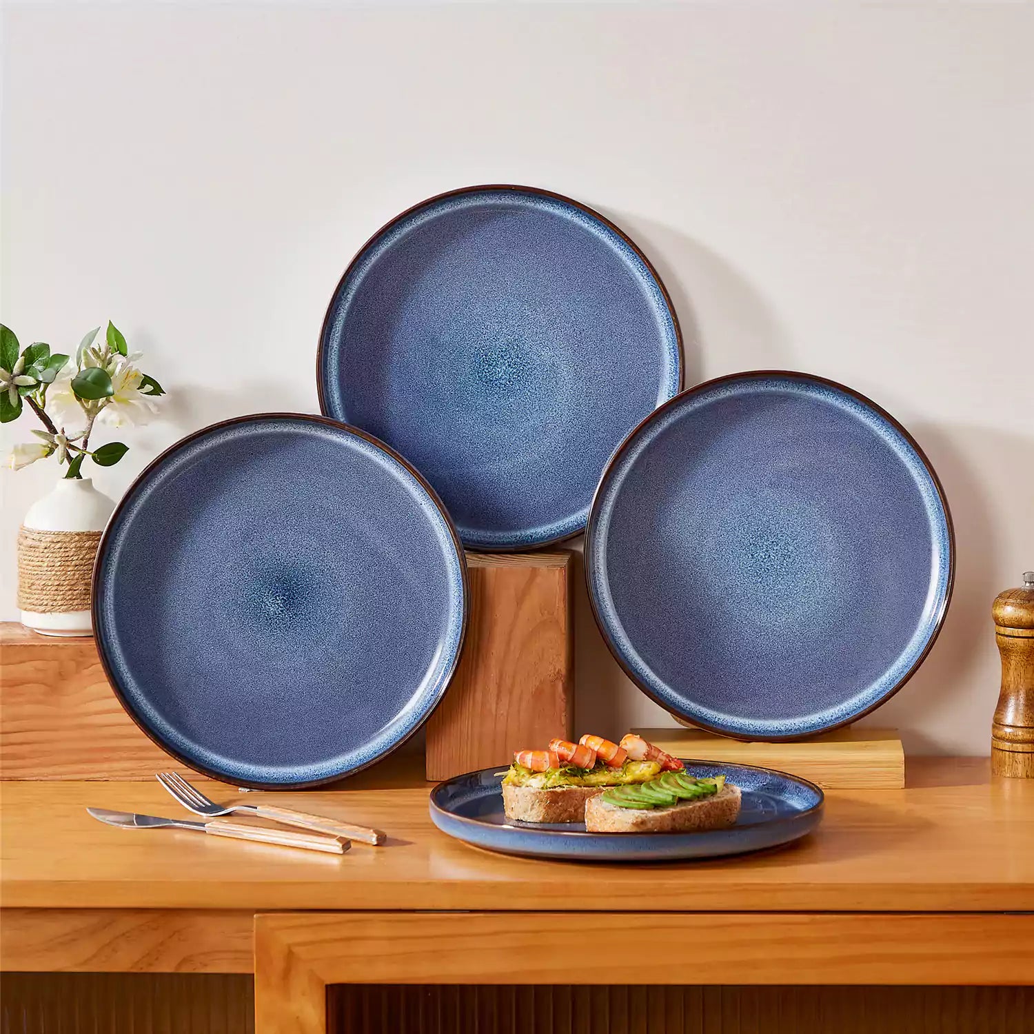 Sata blue stoneware dinner plate set of 4 styled with lamb chops and vegetables on a dinner table farmhouse lipped edge reactive glaze one of a kind finish