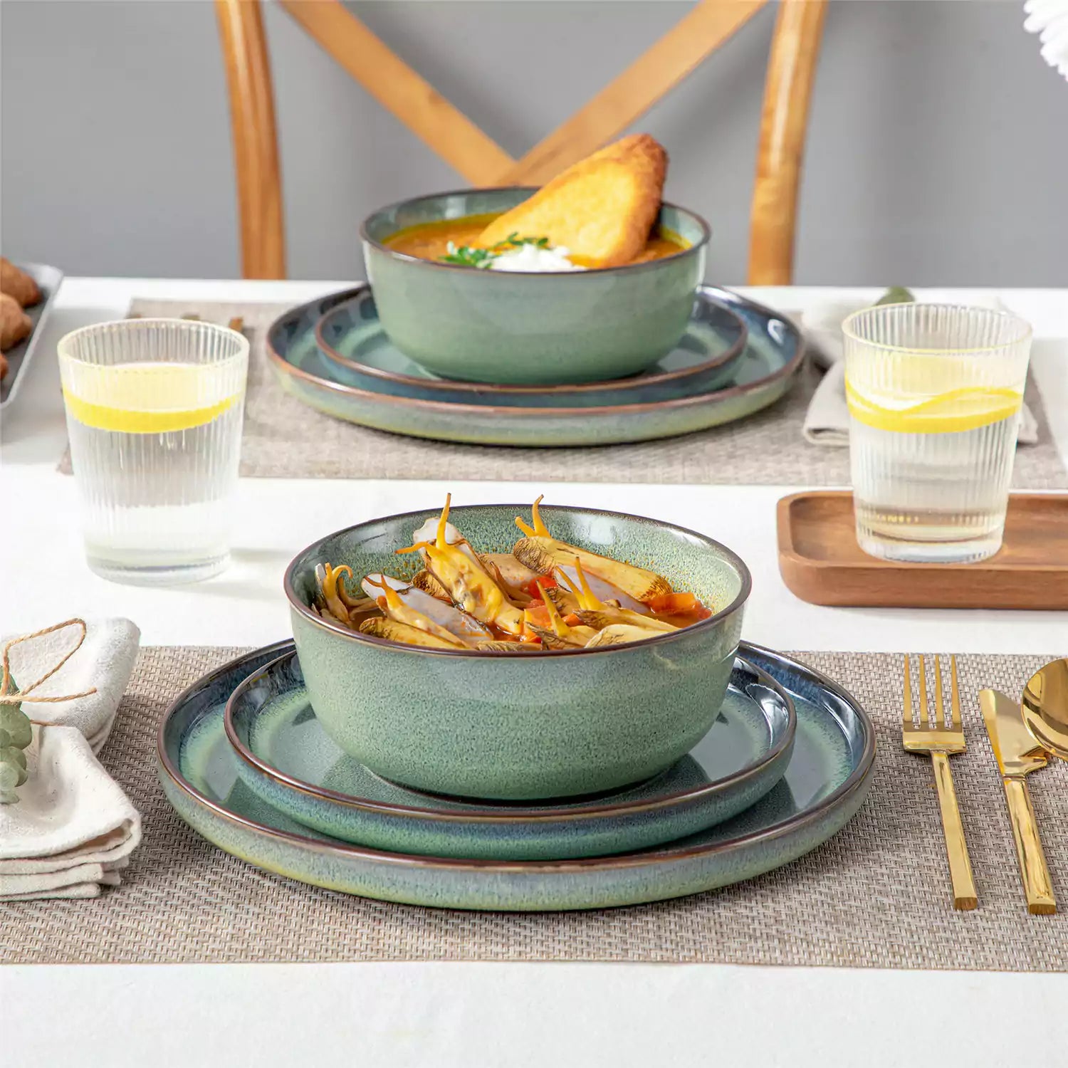 Sata green stoneware 12 piece dinnerware set with dinner plates salad plates and cereal bowls styled with gold cutlery on textured surface farmhouse reactive glaze lipped edge service for 4
