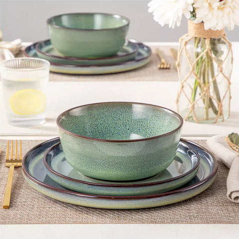 Sata green stoneware 12 piece dinnerware set with dinner plates salad plates and cereal bowls styled with gold cutlery on textured surface farmhouse reactive glaze lipped edge service for 4