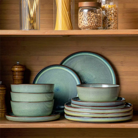 Sata green stoneware 12 piece dinnerware set with dinner plates salad plates and cereal bowls styled with gold cutlery on textured surface farmhouse reactive glaze lipped edge service for 4