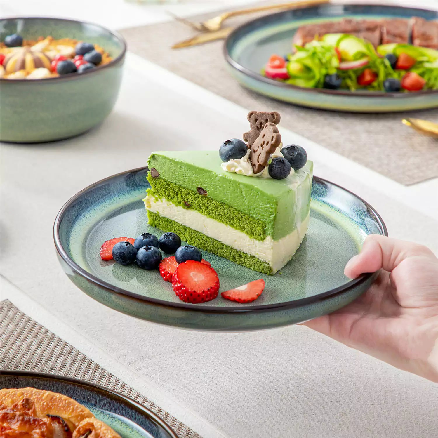 Sata green stoneware 12 piece dinnerware set with dinner plates salad plates and cereal bowls styled with gold cutlery on textured surface farmhouse reactive glaze lipped edge service for 4