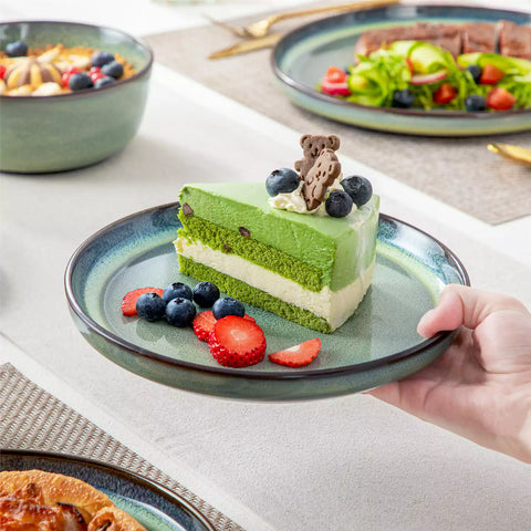 Sata green stoneware 12 piece dinnerware set with dinner plates salad plates and cereal bowls styled with gold cutlery on textured surface farmhouse reactive glaze lipped edge service for 4