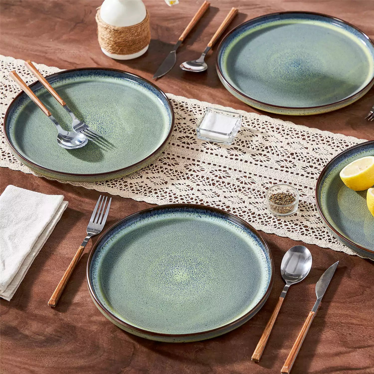 Sata green stoneware dinner plate set of 4 styled with lamb chops and vegetables on a dinner table farmhouse lipped edge reactive glaze one of a kind finish