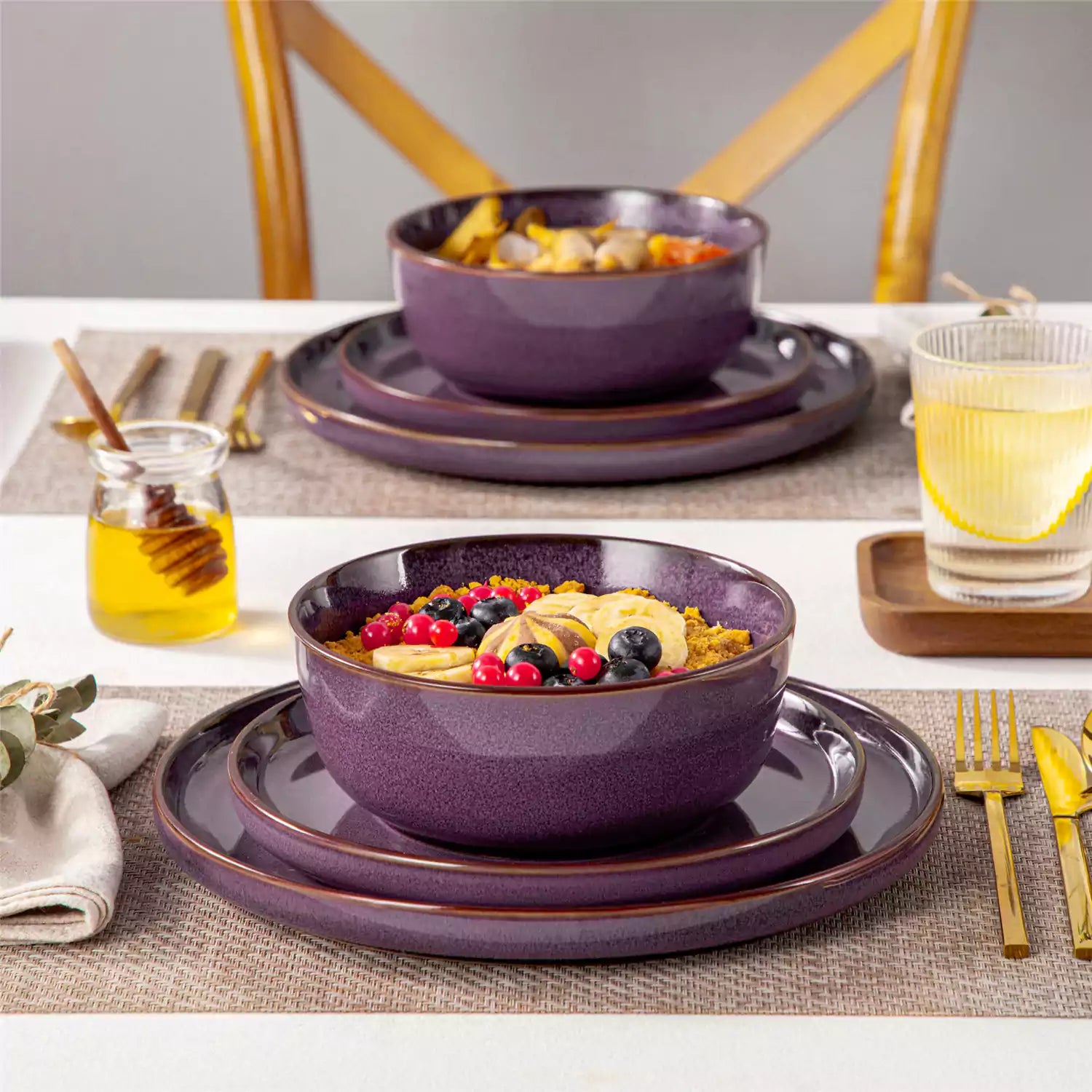 Sata purple stoneware 12 piece dinnerware set with dinner plates salad plates and cereal bowls styled with gold cutlery on textured surface farmhouse reactive glaze lipped edge service for 4