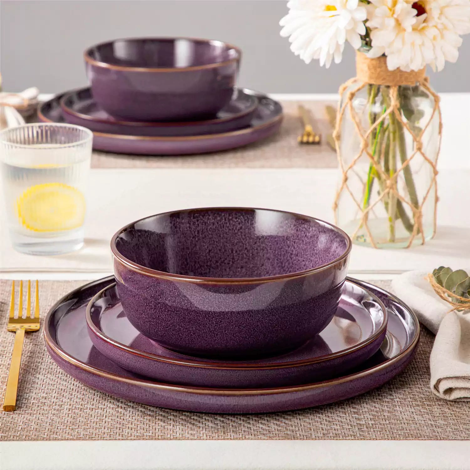 Sata purple stoneware 12 piece dinnerware set with dinner plates salad plates and cereal bowls styled with gold cutlery on textured surface farmhouse reactive glaze lipped edge service for 4