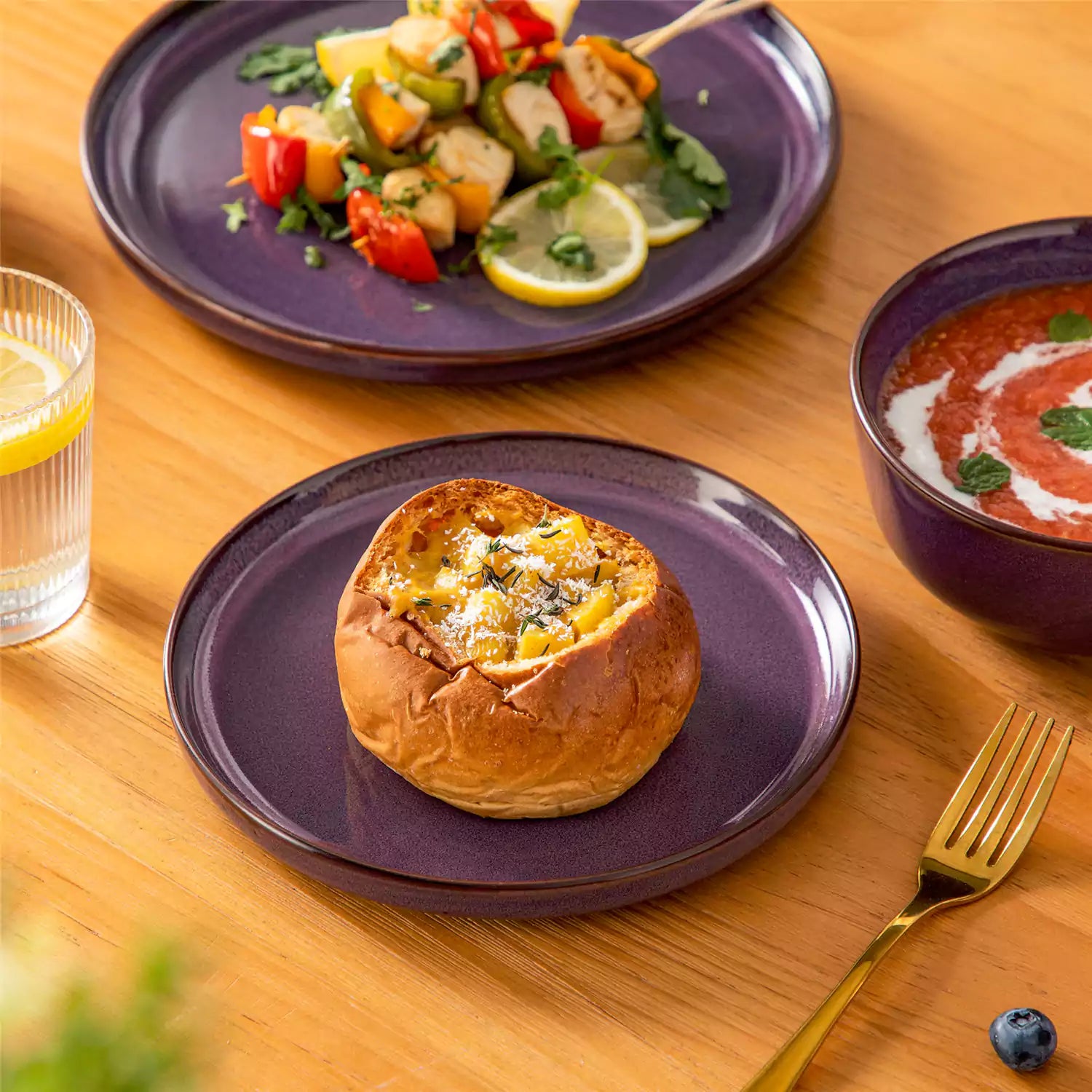 Sata purple stoneware 18 piece dinnerware set with dinner plates salad plates and cereal bowls styled on a wooden table with diverse meal setup farmhouse reactive glaze lipped edge service for 6