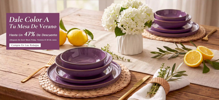 Vajilla de gres morado Sata para 6 personas con platos y cuencos de borde elevado y esmalte reactivo presentada sobre una mesa de madera con hortensias blancas y limones frescos