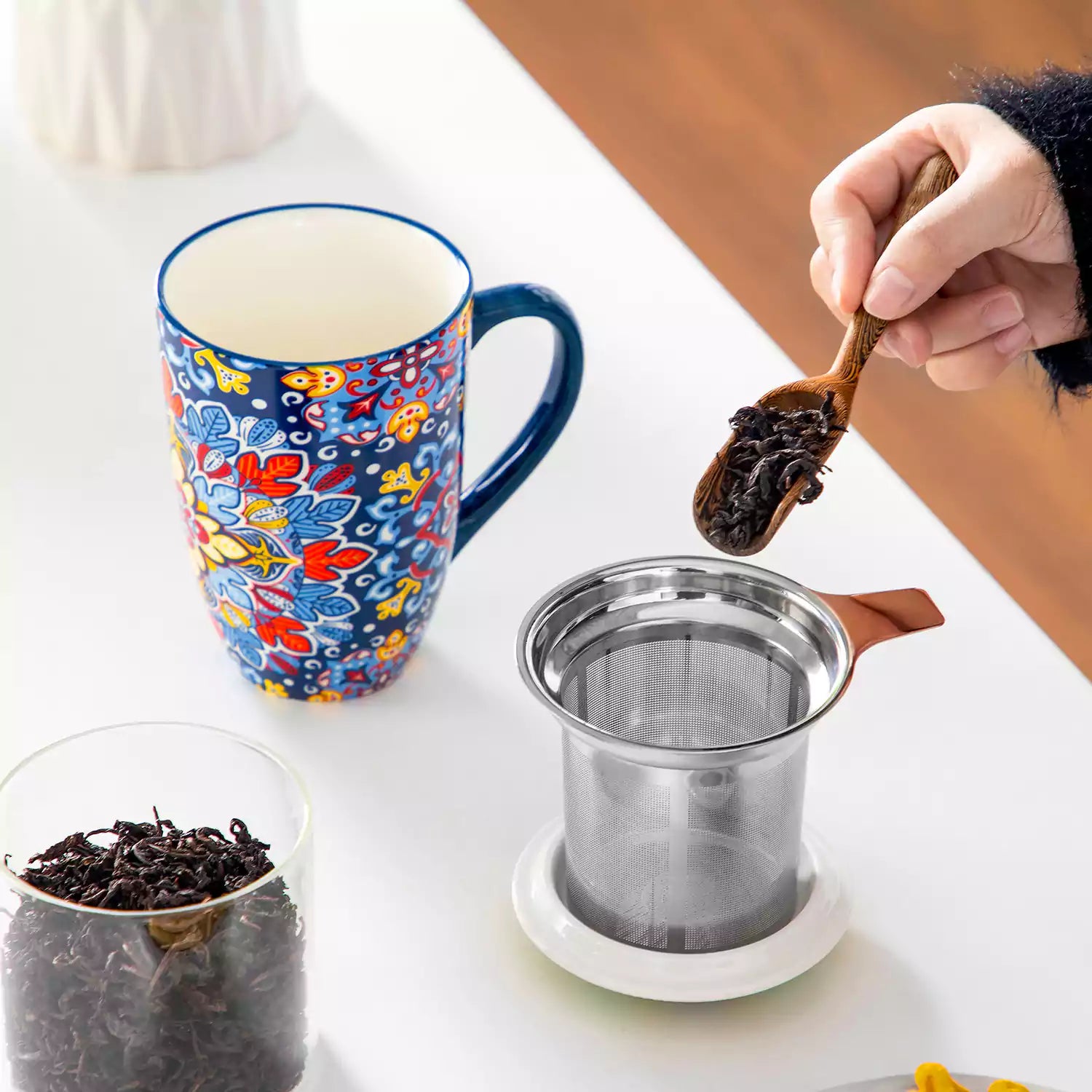 Simi tea mug with infuser and lid colorful navy blue boho chic ceramic coffee cup with spoon and loose tea leaves on white background