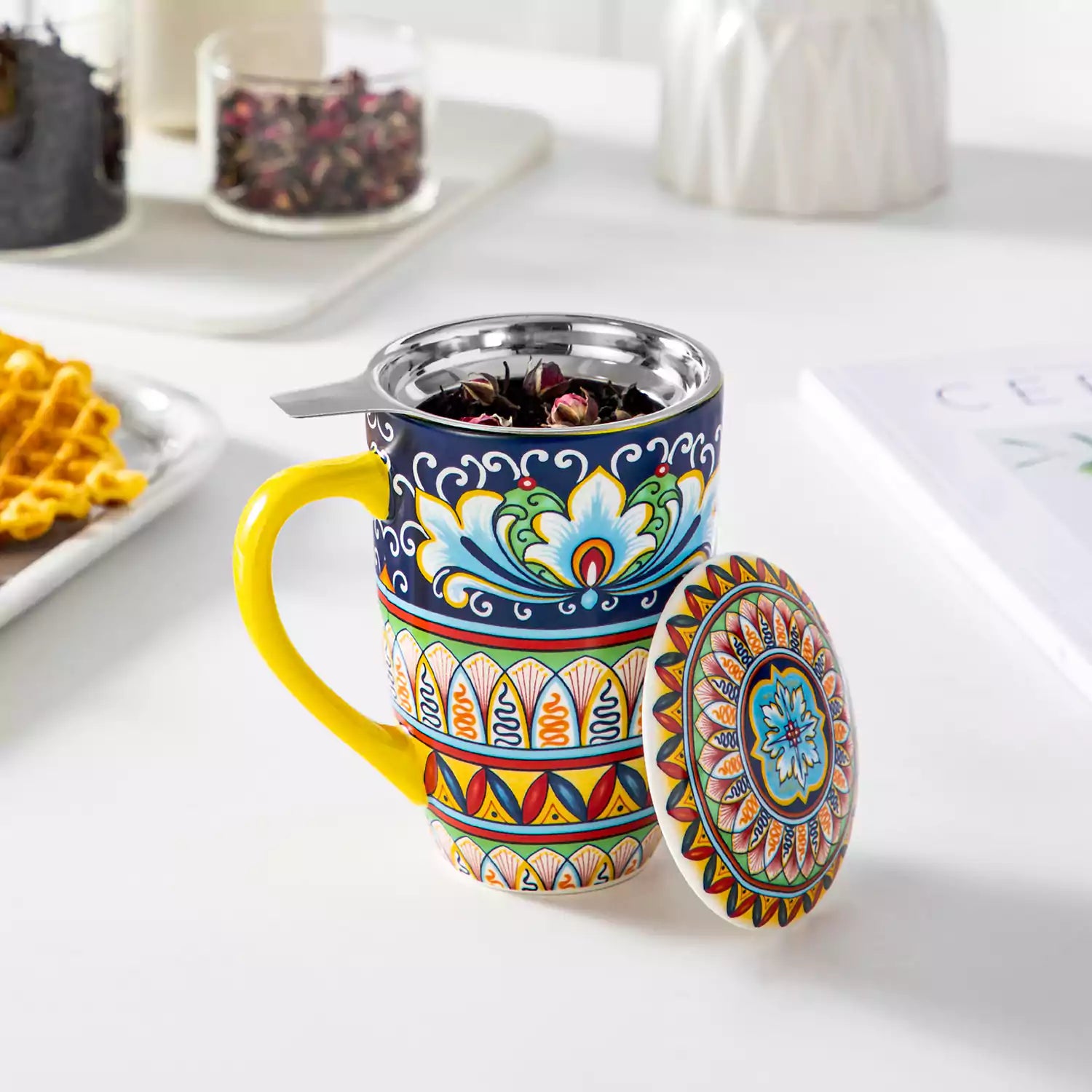 Simi tea mug with infuser and lid colorful golden yellow boho chic ceramic coffee cup with spoon and loose tea leaves on white background