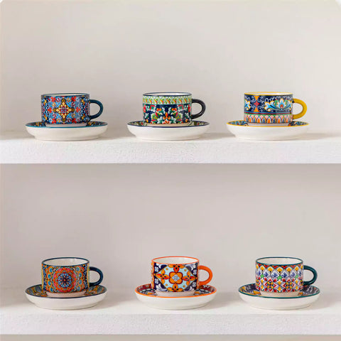 Simi 12 piece porcelain espresso set with 3oz cups and saucers in vibrant boho chic floral patterns on a black metal storage rack with a magazine and napkin on a wooden table