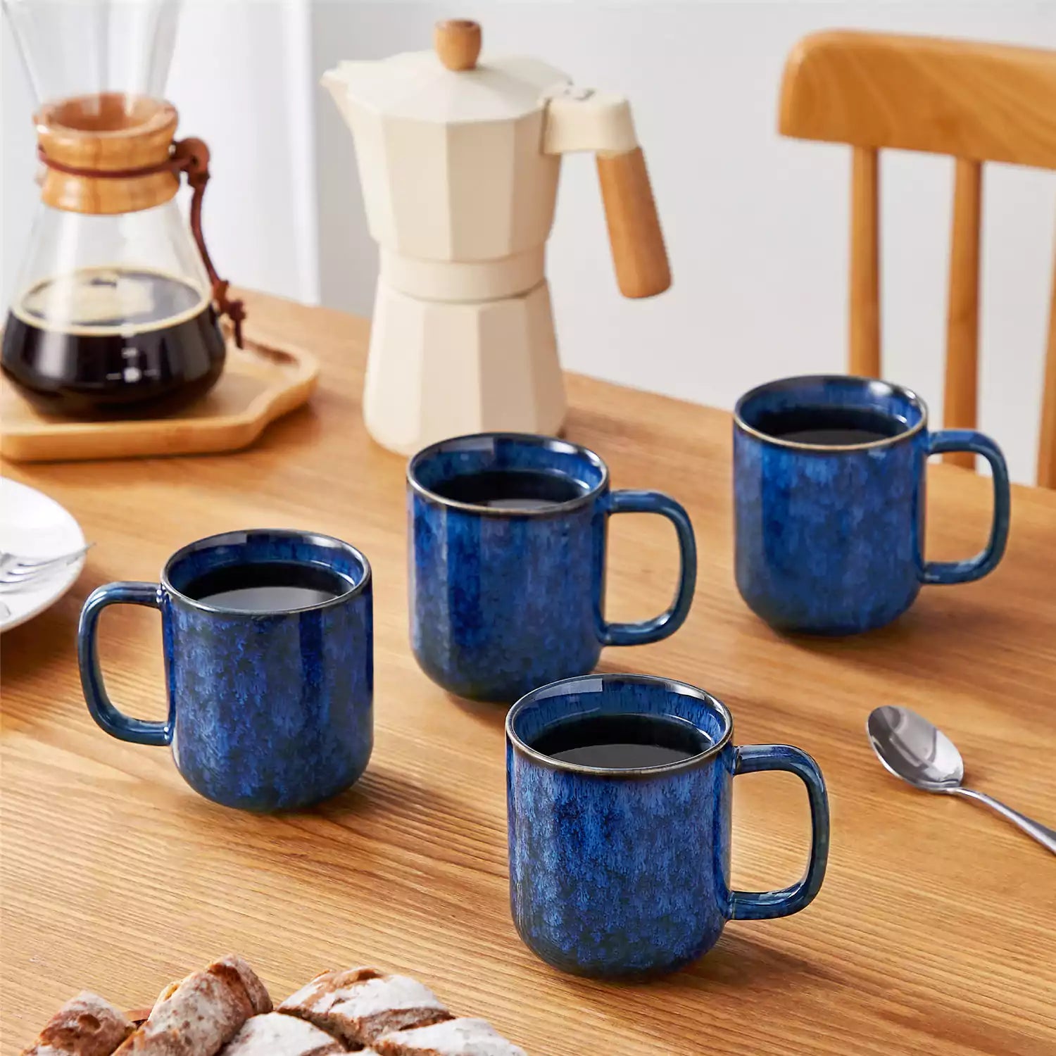 Starry blue 12oz stoneware mugs set of 4 with coffee on wooden table next to coffee maker and fresh bread cozy breakfast scene