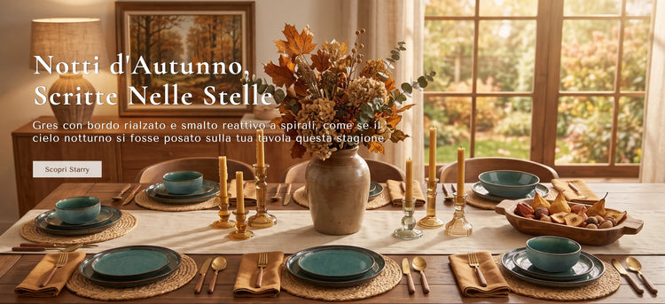 Una tavola apparecchiata a tema autunnale in una stanza calda e luminosa. Il tavolo è arredato con ciotole in ceramica verde acqua, posate dorate, tovagliette intrecciate e un grande vaso centrale pieno di foglie autunnali.