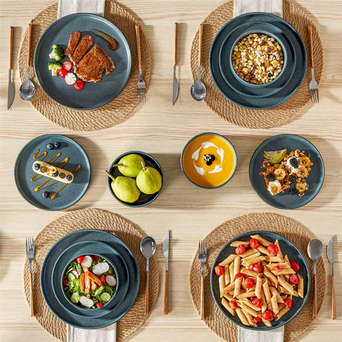 Blue reactive glaze stoneware dinner plates styled with food on rustic wood table with woven placemats modern minimalist tableware set