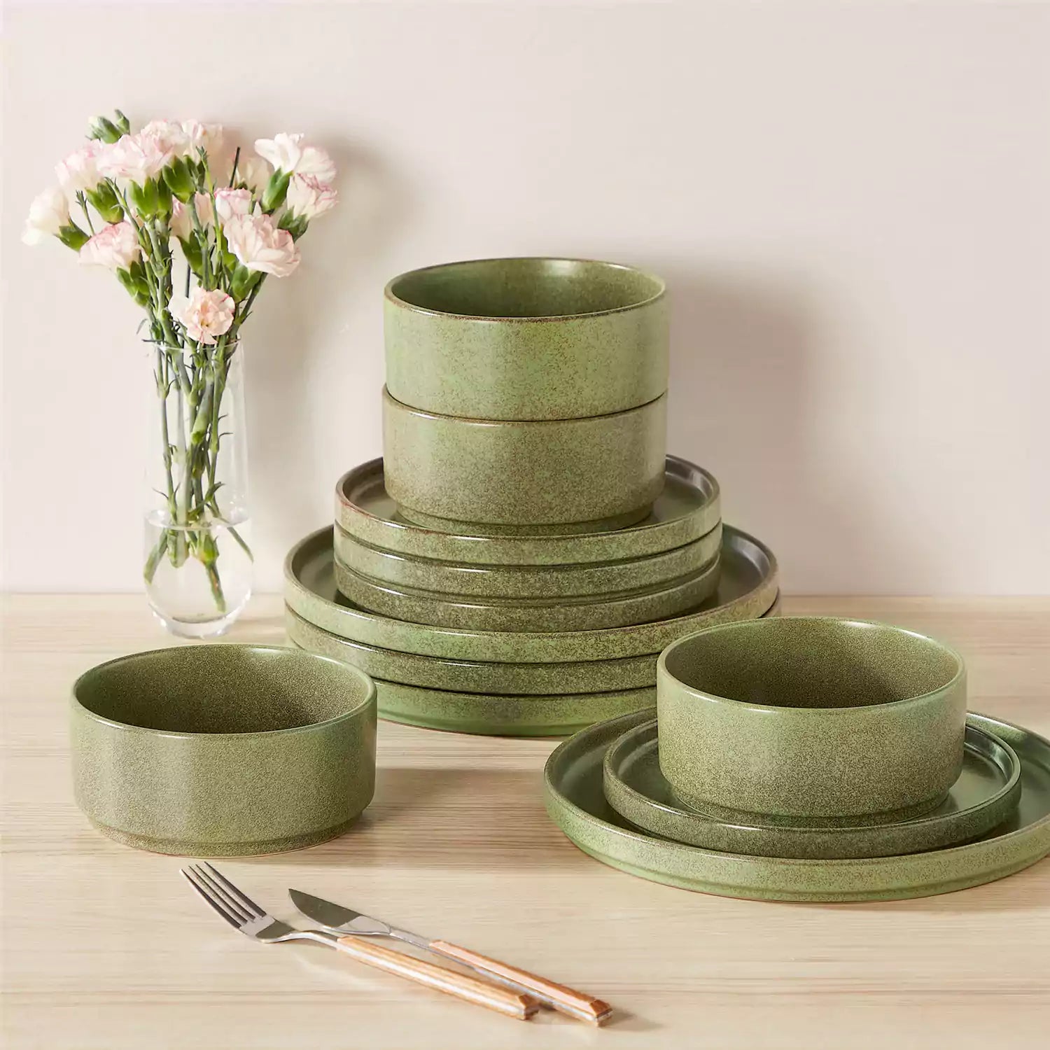 Green reactive glaze stoneware dinner plates styled with food on rustic wood table with woven placemats modern minimalist tableware set