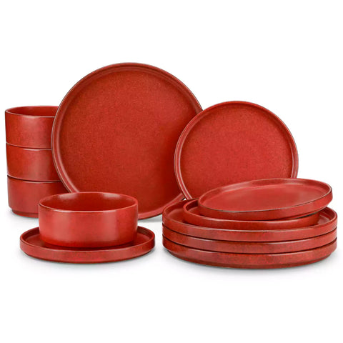 Red reactive glaze stoneware dinner plates styled with food on rustic wood table with woven placemats modern minimalist tableware set