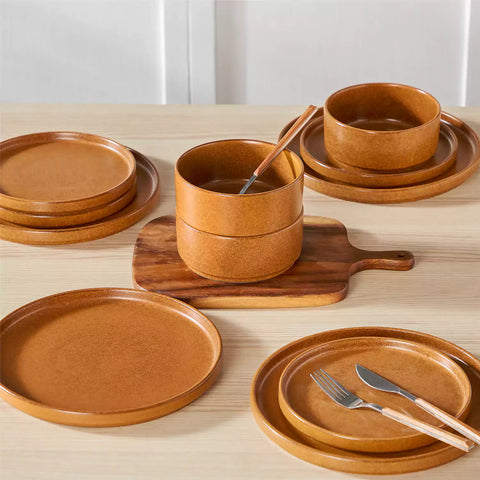 Caramel reactive glaze stoneware dinner plates styled with food on rustic wood table with woven placemats modern minimalist tableware set