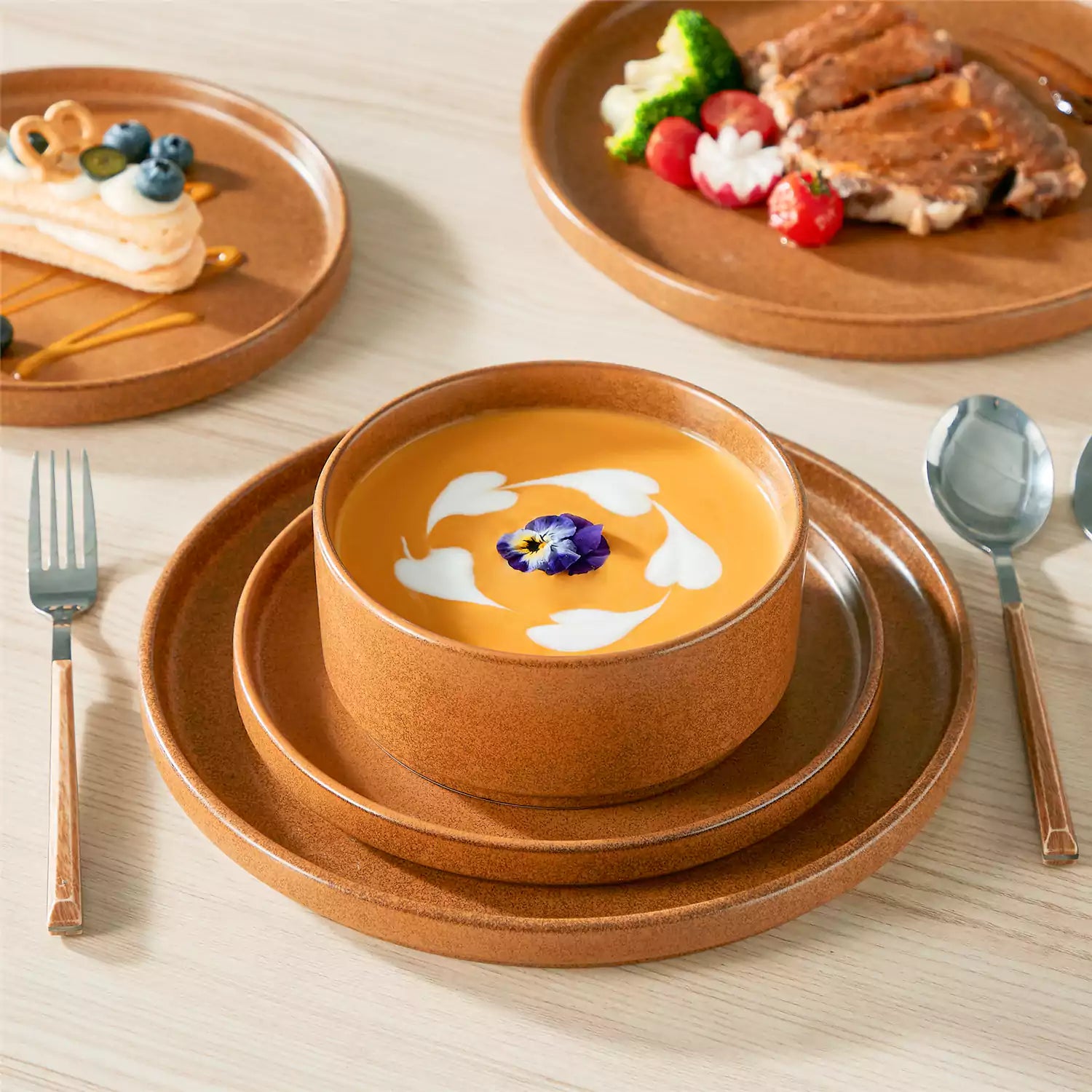 Caramel reactive glaze stoneware dinner plates styled with food on rustic wood table with woven placemats modern minimalist tableware set